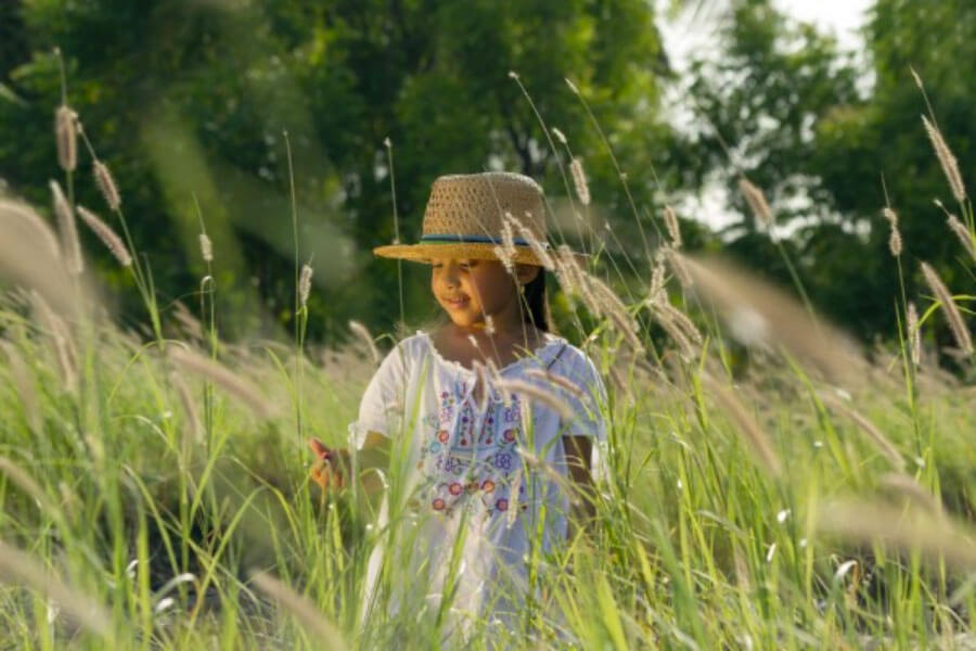 A young girl in a field with Cattails