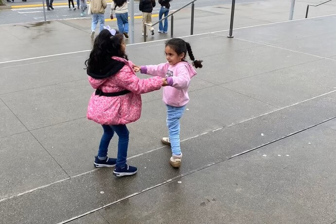 two young girls dancing outside