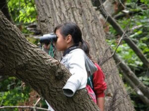 Girl looking through binoculars.