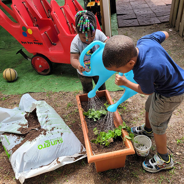 Children water plants after setting up their container garden at Trusting Hands Family Child Care Home. Photo courtesy of Smart Start of New Hanover County. 