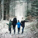 Family walking outdoors in a snow covered forest.