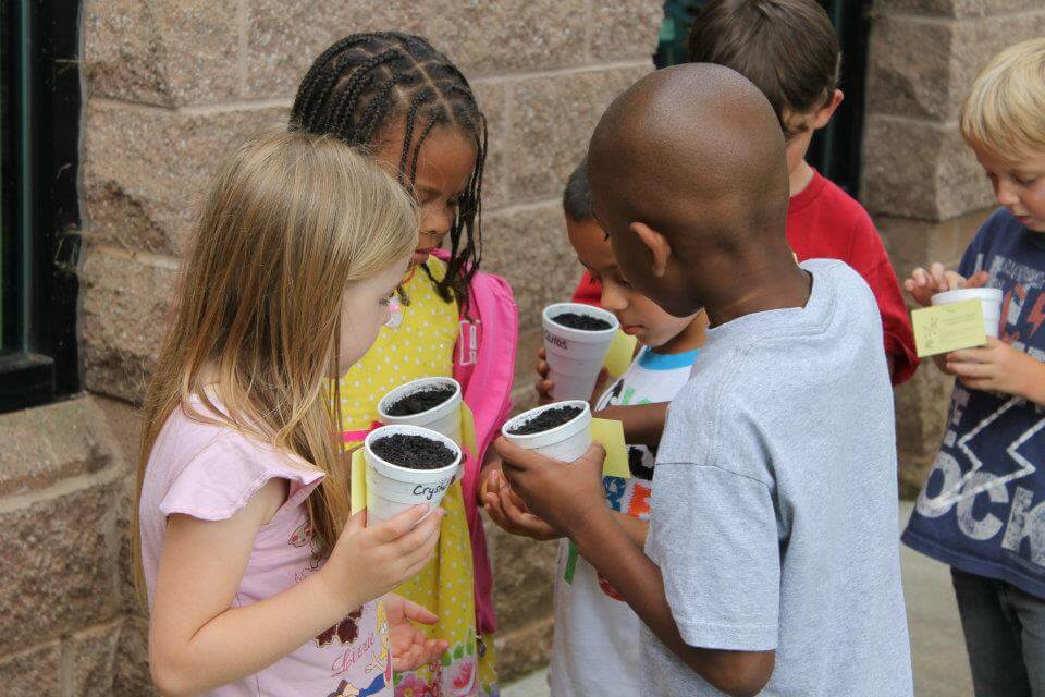 Children planting seeds together.
