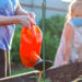 Kids watering a garden.